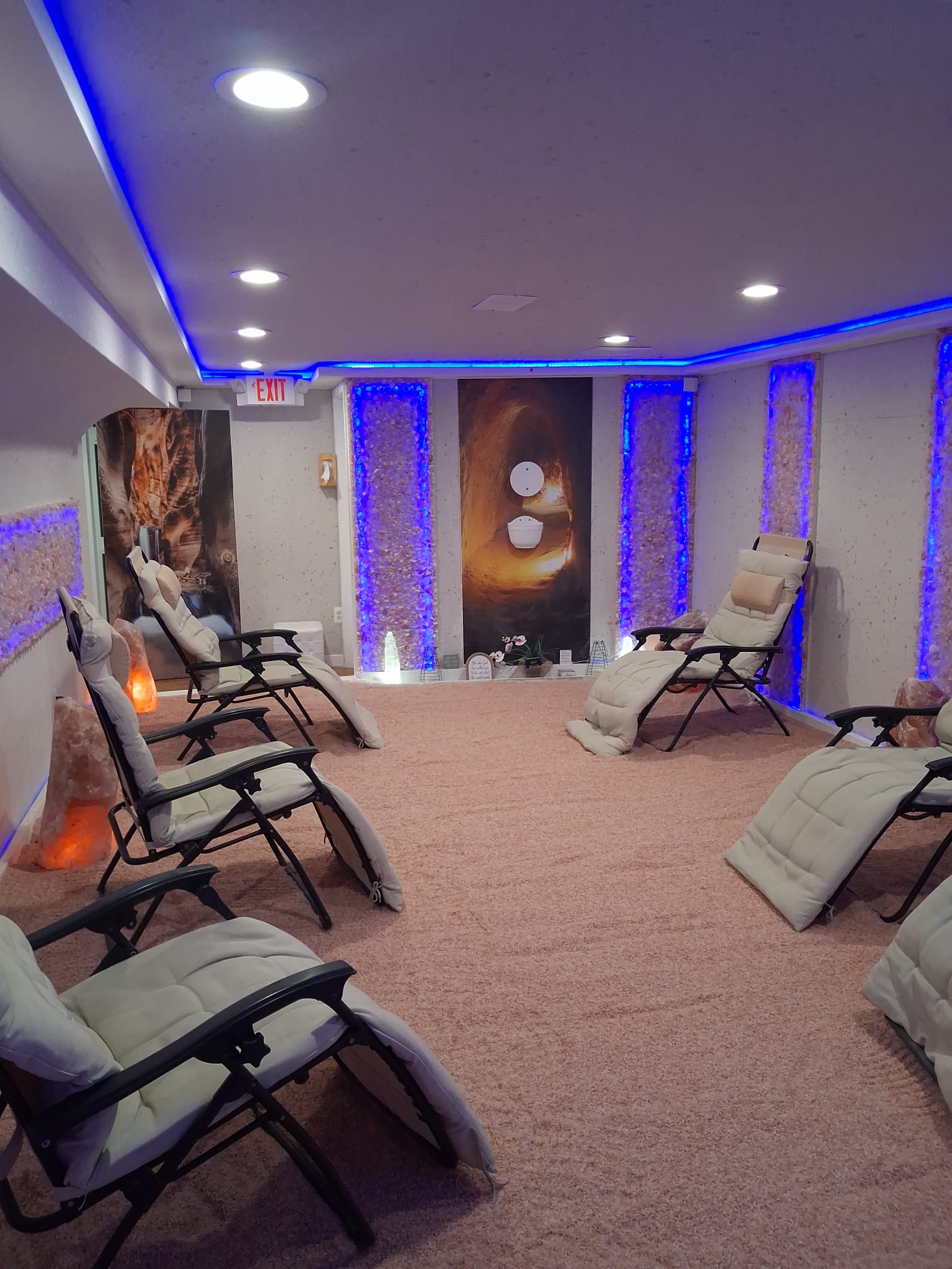 Himalayan salt room with reclining chairs, glowing salt panels and canyon-inspired wall art